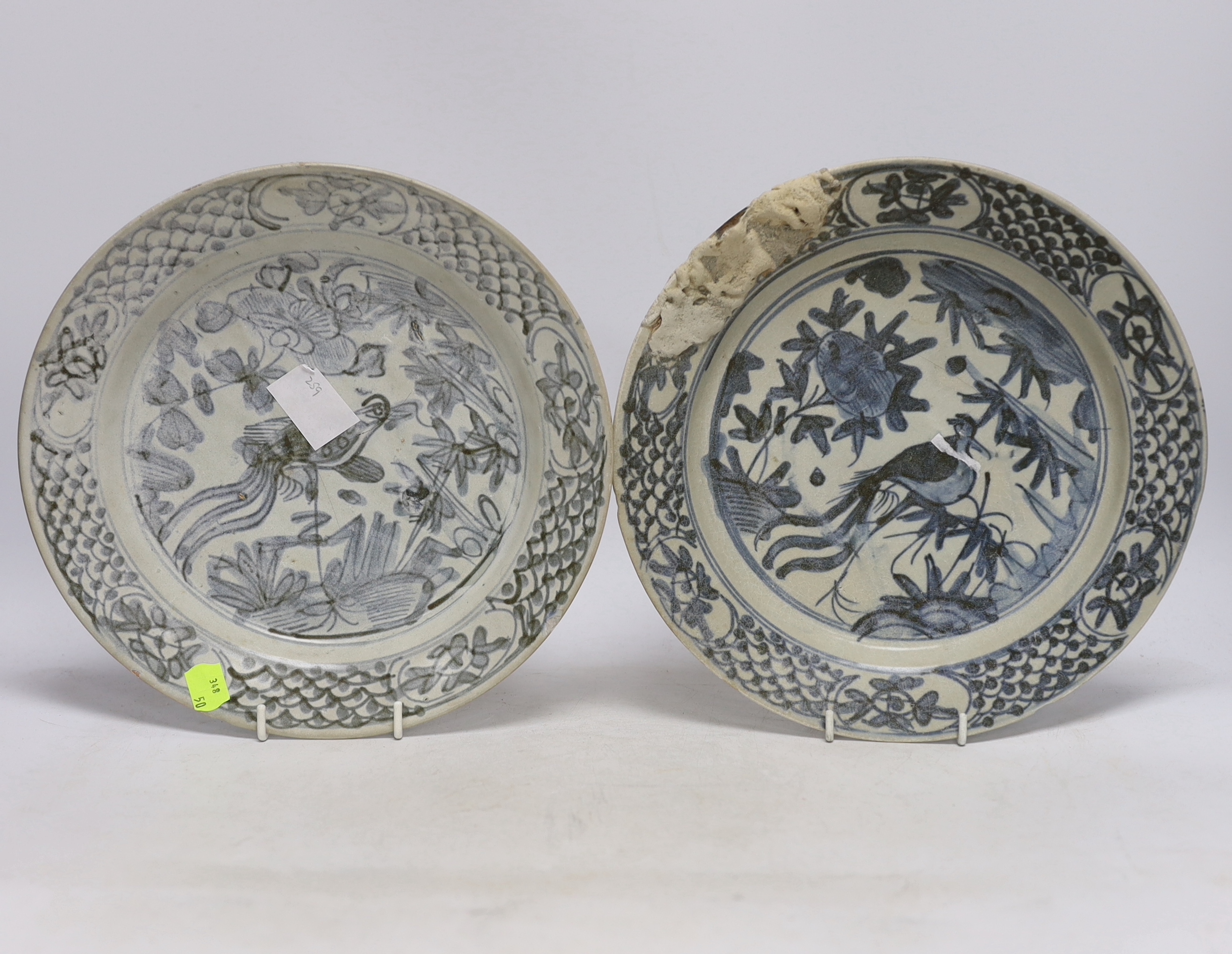 A pair of Chinese Swatow blue and white 'phoenix' plates, late Ming, Binh Thuan shipwreck, 26cm diameter (a.f.)